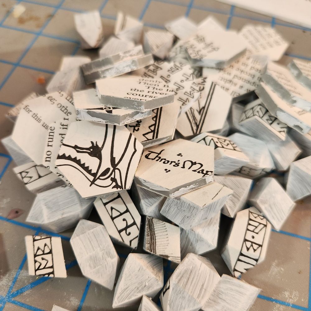 3d printed dice cores with pasted pages from The Hobbit. 
