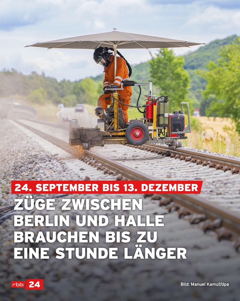 Ein Gleisarbeiter in orangener Schutzkleidung und Helm arbeitet mit einem Schienenschleifgerät auf einem Bahngleis. Über ihm ist ein großer Sonnenschirm befestigt. Im Hintergrund sind grüne Bäume, Hügel und eine Landstraße zu sehen. Auf dem Bild liegt ein halbtransparenter Textblock: „24. September bis 13. Dezember – Züge zwischen Berlin und Halle brauchen bis zu eine Stunde länger“. Unten links ist das Logo von rbb24, unten rechts die Bildquelle „Bild: Manuel Kamuf/dpa“ eingeblendet.