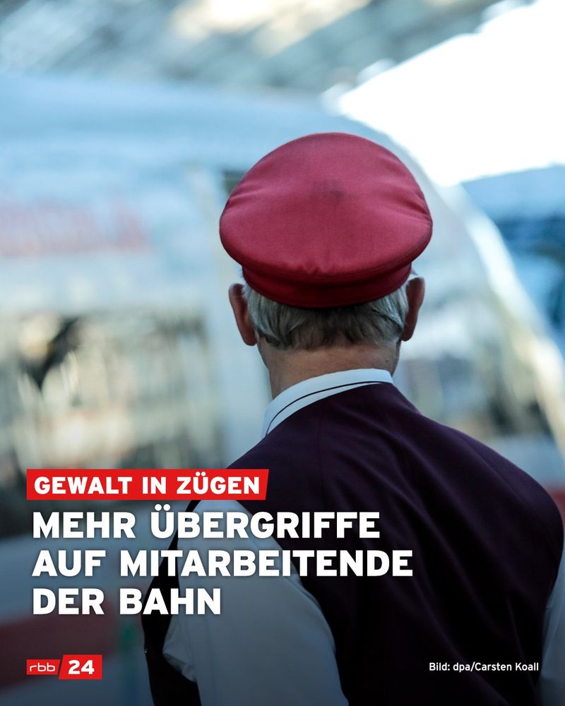 Ein Zugschaffner steht am Bahnsteig. Man sieht ihn von hinten. Er blickt nach rechts. Vor ihm steht ein ICE.