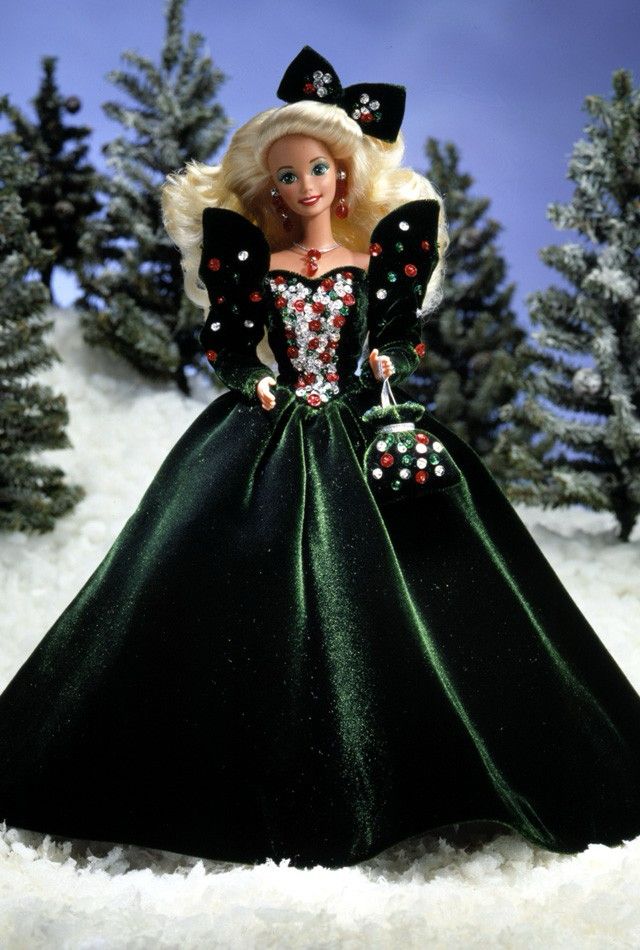 Barbie doll wearing a green velvet gown, embroidered with silver, red, and green sequins on the bodice and sleeves