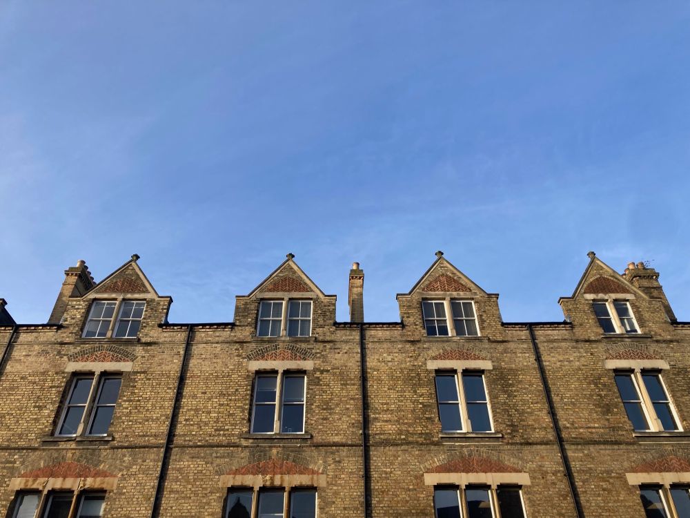 Brick buildings pointing up into a blue sky, with wispy clouds!