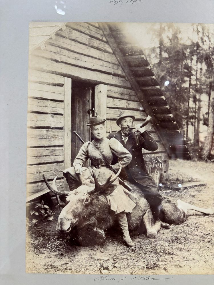 Photographie ancienne d'un couple assis sur la dépouille d'un élan à la chasse
