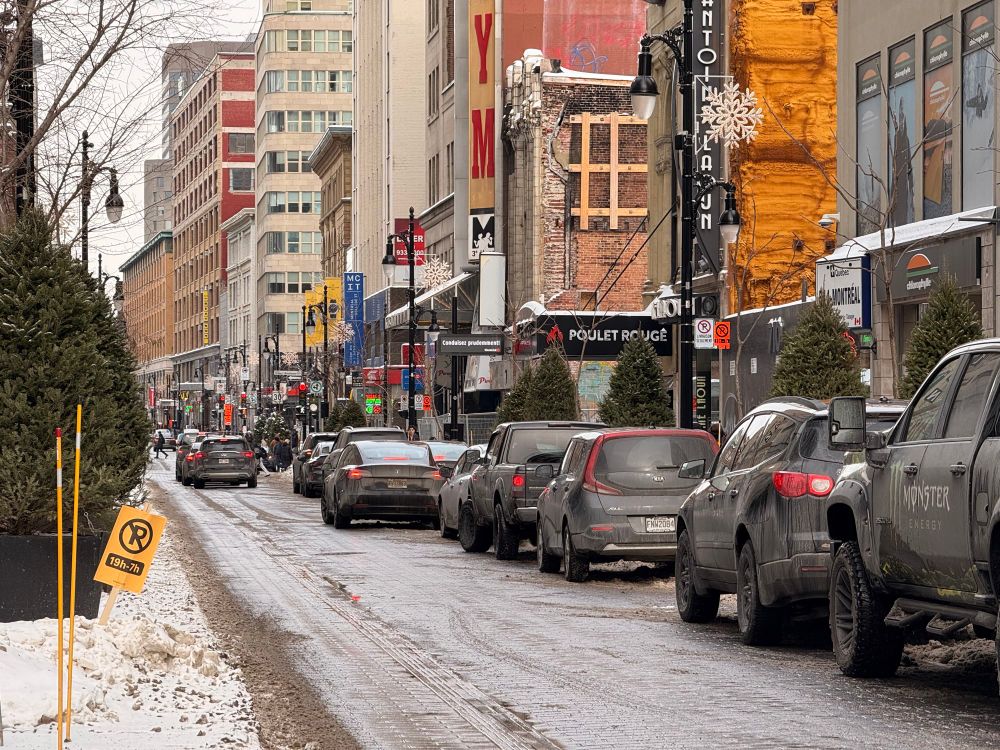 voitures stationnées à moitié sur le trottoir sur sainte-catherine à proximité du centre eaton.

cars parked on the sidewalk on sainte-catherine street near eaton centre.