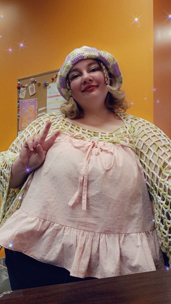 Morgan in her tank top, paired with jeans, a mesh crochet shrug, and a checkered bucket hat