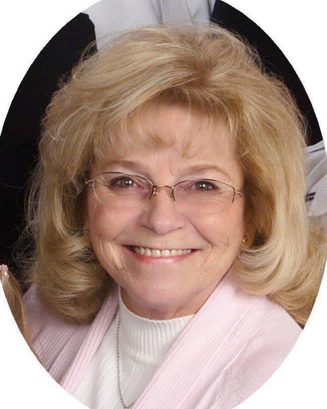 A picture of my beautiful mother! She had shoulder-length blonde hair and is wearing a pink sweater and wire-rimmed glasses.