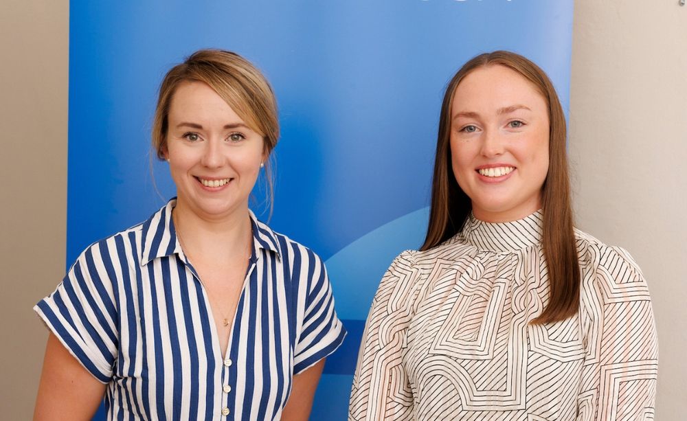 two young women smile at the camera