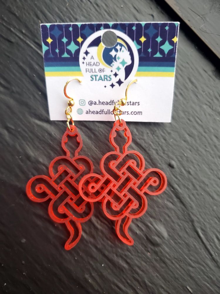 Red acrylic mystic knot-shaped snake earrings.