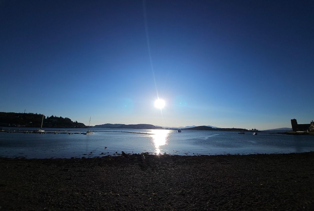 Sun going down over the bay in Oban, reflecting in the ocean