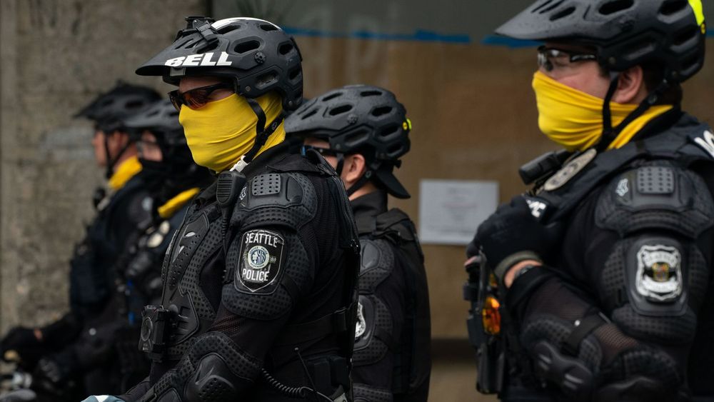 Seattle bicycle police with faces hidden with yellow gaiters.