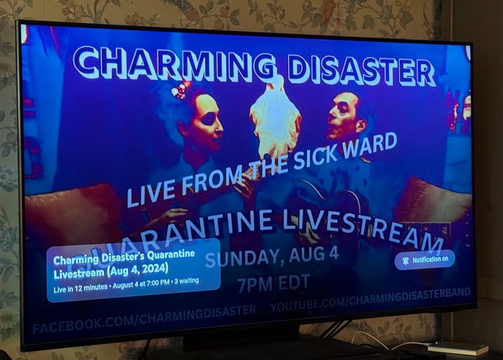 Photo of a TV screen displaying the countdown page for the latest Charming Disaster Quarantine Livestream (Aug. 4, 2024 @ 7pm eastern.