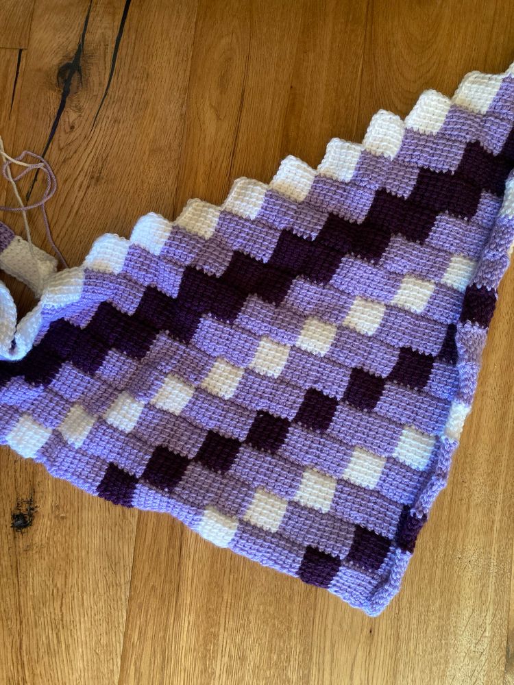 Purple, white and dark purple shawl, not finished, Tunisian entrelac crochet.