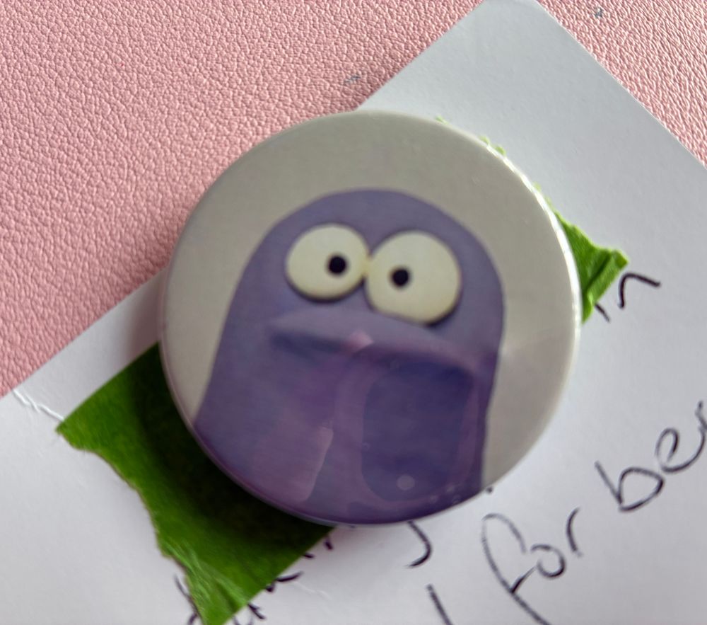 A button with Terry stuck on a postcard. 