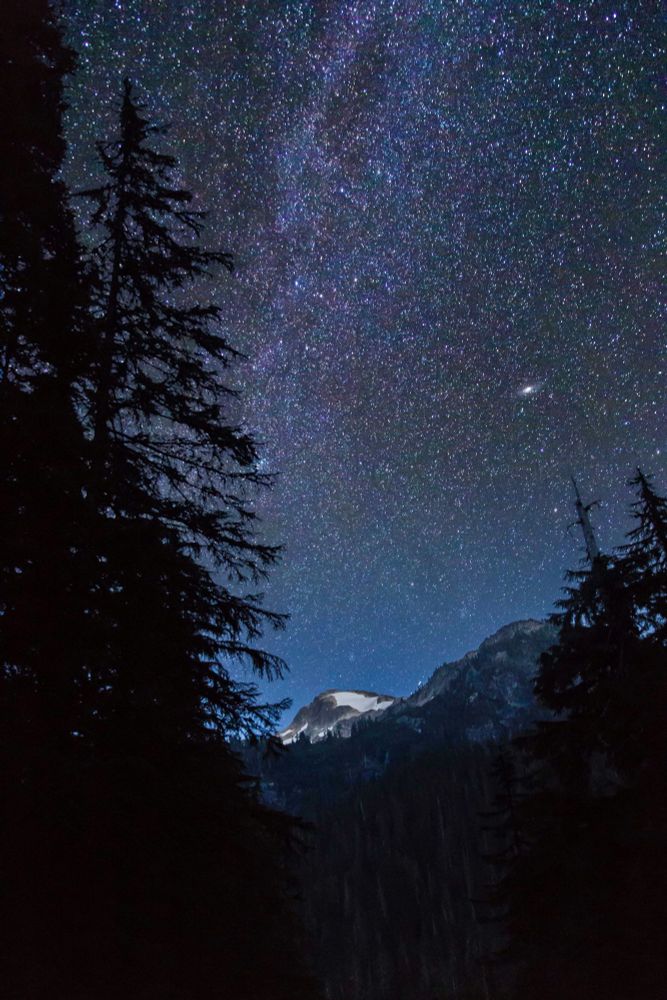 The Milky Way Arcs above Peaks - ©Andy Porter
Description:
The glow of the sky and the emerging Milky Way rise above the twilit mountain peaks and forests of the North Cascades.