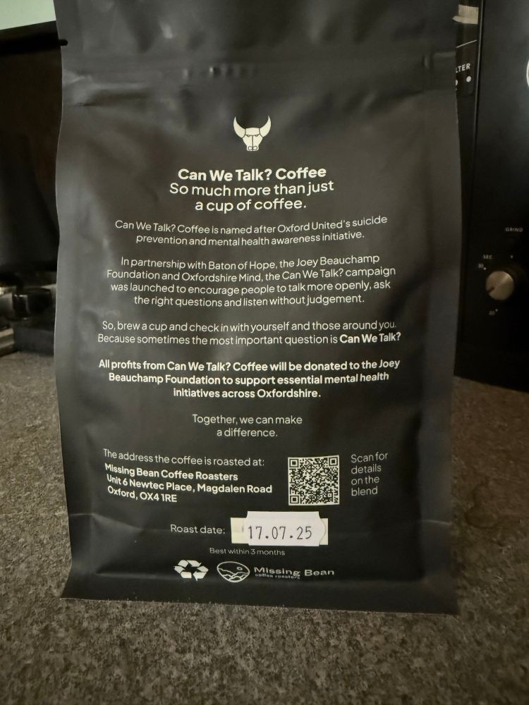 The back of the black bag of coffee beans, with the following words printed on it in white:
Can We Talk? Coffee So much more than just a cup of coffee.
Can We Talk? Coffee is named after Oxford United's suicide prevention and mental health awareness initiative.
In partnership with Baton of Hope, the Joey Beauchamp Foundation and Oxfordshire Mind, the Can We Talk? campaign was launched to encourage people to talk more openly, ask the right questions and listen without judgement.
So, brew a cup and check in with yourself and those around you.
Because sometimes the most important question is Can We Talk?
All profits from Can We Talk? Coffee will be donated to the Joey Beauchamp Foundation to support essential mental health initiatives across Oxfordshire.