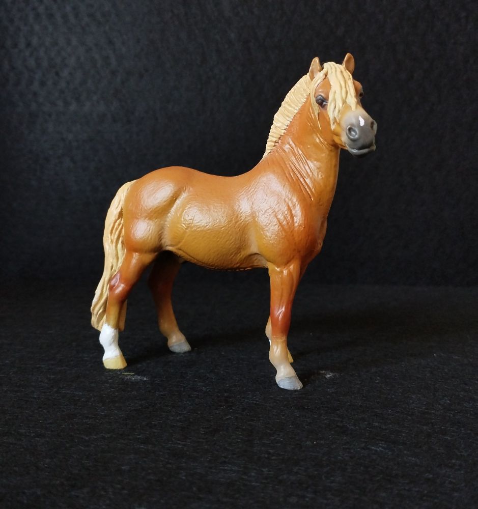 Chestnut fjord model horse with lighter mane and tail and a spot on it's nose