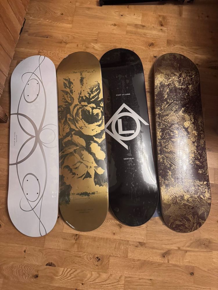 Des planches de skate avec différents motifs dorés / noirs / blancs sur thème du groupe Cult of Luna. 