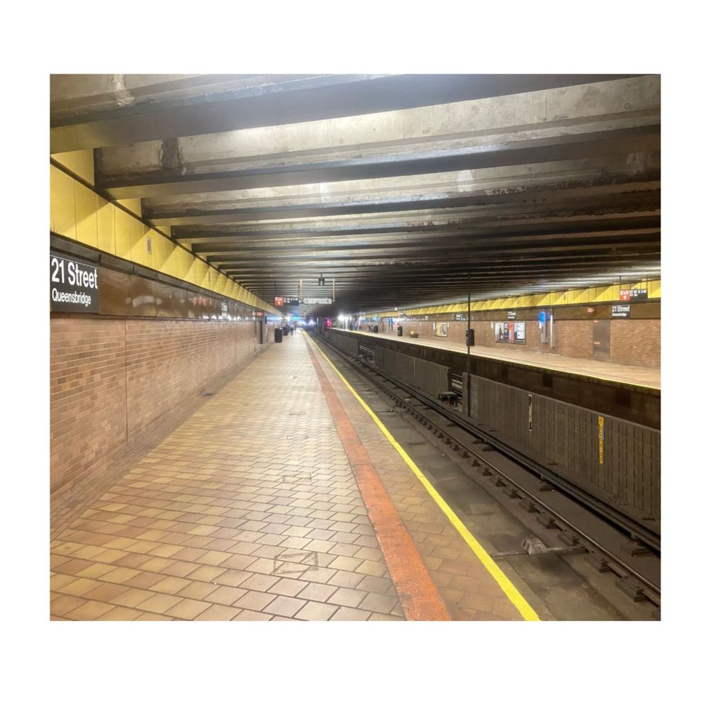 Photo of a brightly lit subway platform, looking down the length of the track