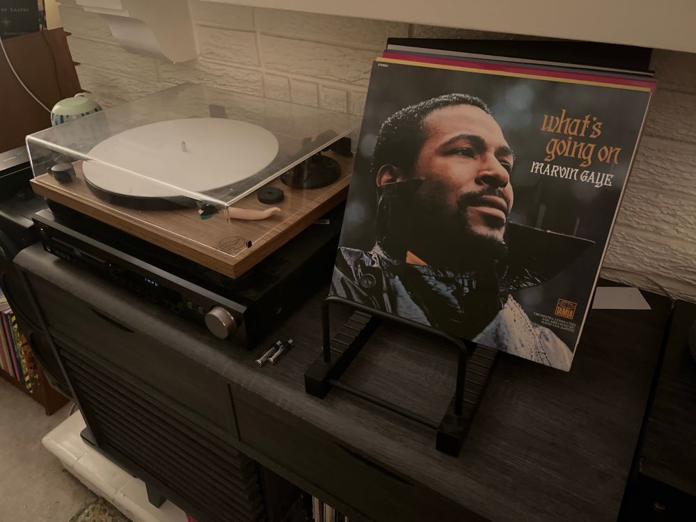 A record player and record stand displaying the album What's Going On by Marvin Gaye