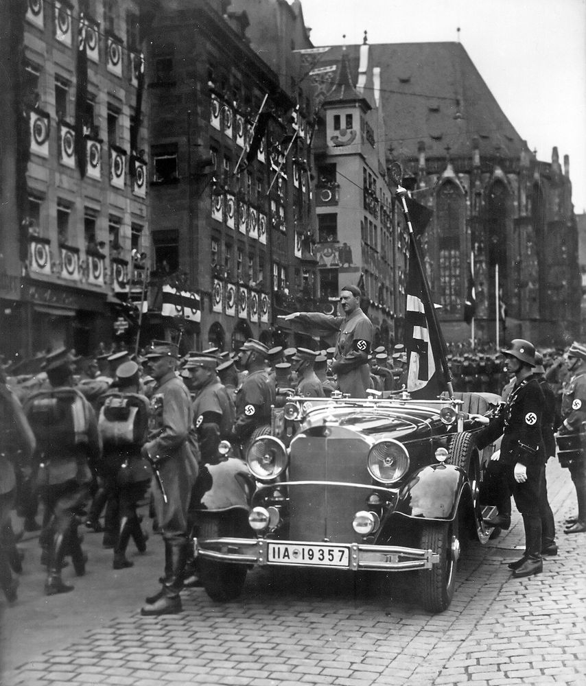 Photographie en noir et blanc d'un défilé des troupes SA nazies devant Hitler à Nuremberg en 1935.