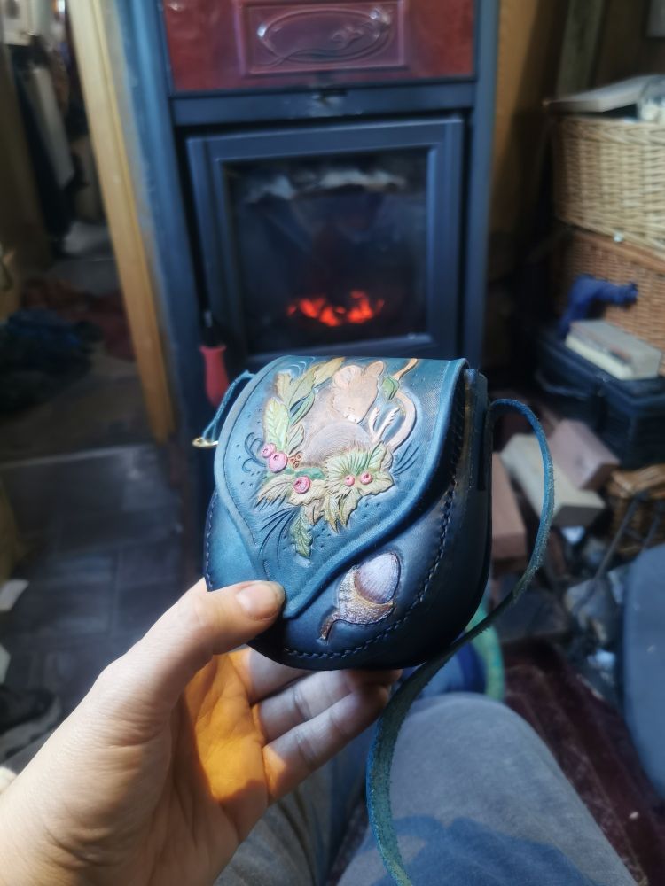 Finished blue handbag with realistic mouse and foliage tooling.