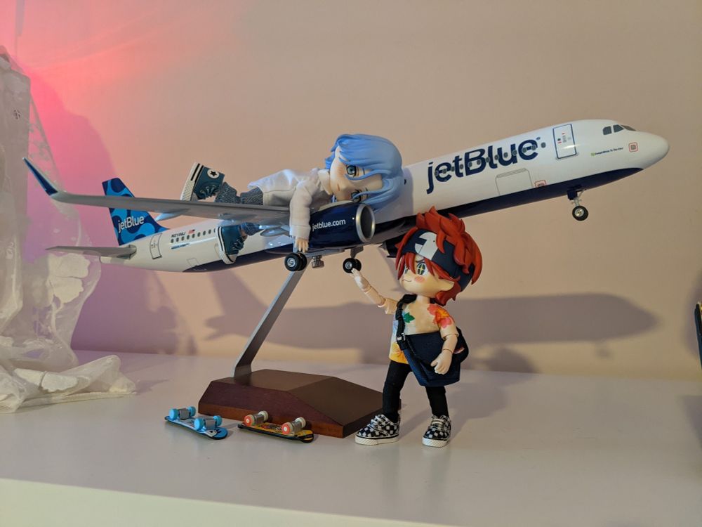 Reki and Langa nendoroid/obitsu dolls posed around a model plane