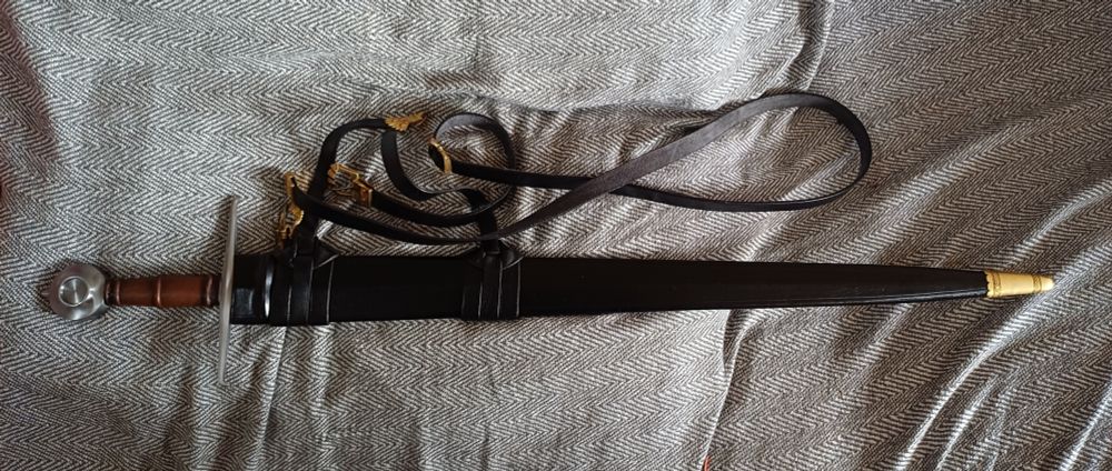 Reproduction Castillon type XV sword with scabbard and belt. Sword is sheathed.