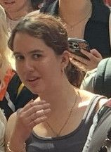 détail de la photo citée recadrée sur une jeune femme dans l'assistance qui observe la scène de façon dubitative/gênée