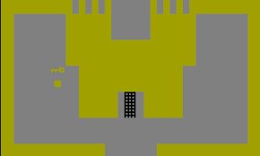 A screenshot of the iconic castle gate from Adventure for the Atari 2600. Abstract and blocky, yellow castle walls with a black portcullis.