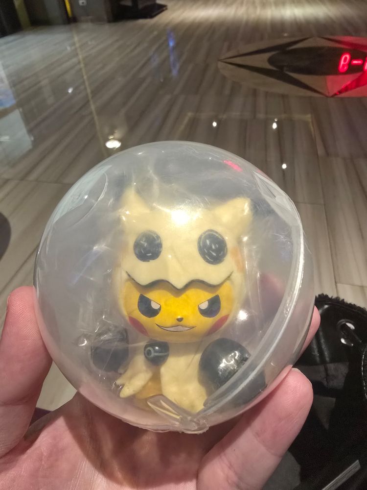 A toy: smirking Pikachu in a Mimikyu costume. 
