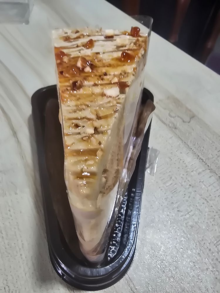 Downward shot of a cream colored cake glazed with some sweet- looking substance. 