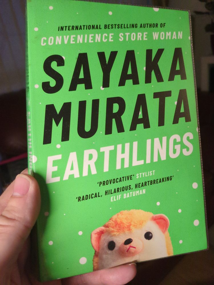 A bright green book entitled Earthlings by Sayaka Murata.