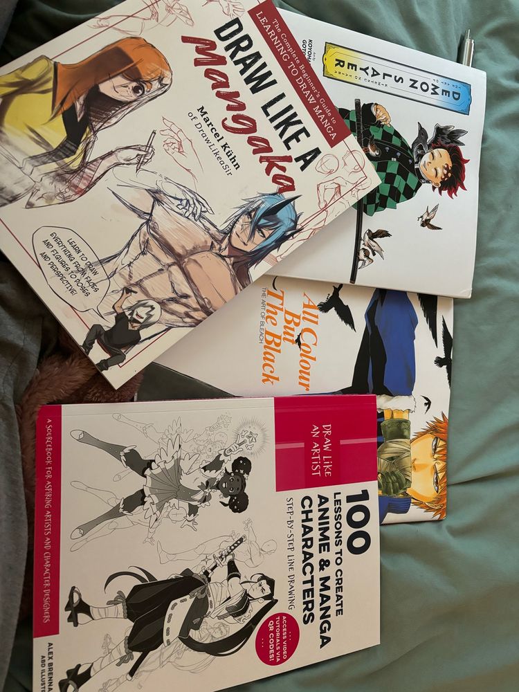 Pile of books: 100 Lessons to Create Anime & Manga Characters, Draw Like a Mangana, The Art of Demon Slayer, All Color But The Black - The Art of Bleach