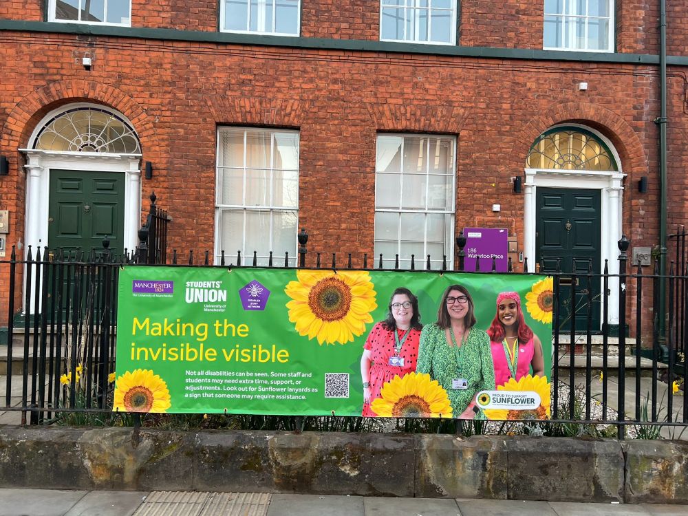 Alt text: photo showing Making the Invisible Visible banner on university of Mcr campus.