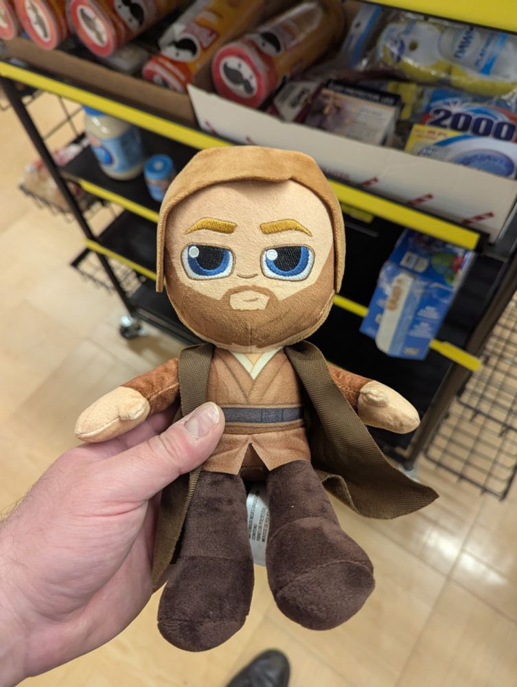a cute doll in the likeness of obi wan kenobi as portrayed by ewen McGregor in Star wars episodes 2 and 3