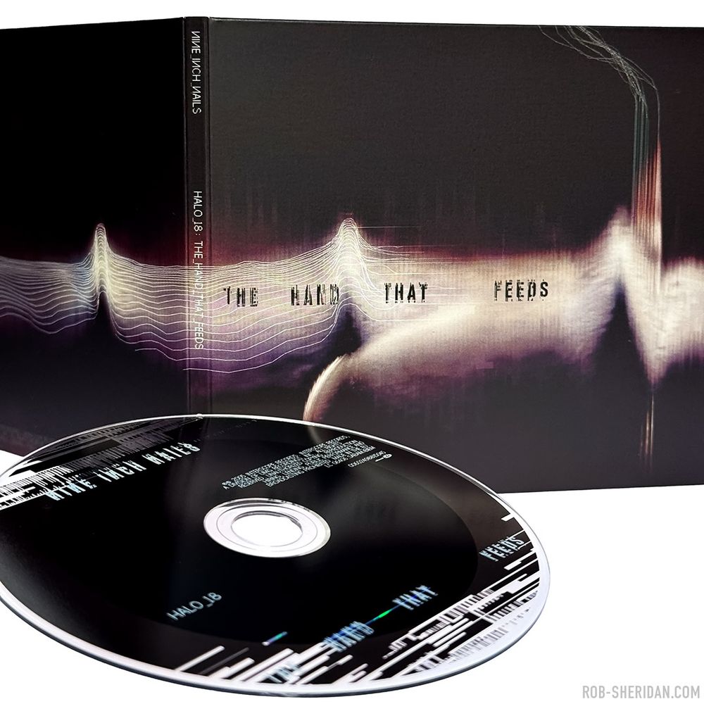 Photo of the exterior of Nine Inch Nails “The Hand That Feeds” CD single package, released March 2005. Cover/interior artwork created by Rob Sheridan with damaged scanner glitching techniques and hand-drawn digital pixel linework. The digital lines that ran throughout the NIN “With Teeth” aesthetic were inspired by (and sometimes taken directly from) low-res scientific graphs and data imagery. In this case I drew them tracing the topography of the textural element, attempting to quantify it, seeking meaning in its form: at once a strange landscape, distant mountains, a seismogram, an electrocardiogram, a cloud nebula… And of course I had Joy Division’s iconic “Unknown Pleasures” album cover in mind as I was making this.