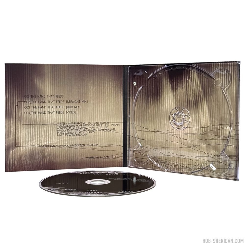 Photo of the interior of Nine Inch Nails “The Hand That Feeds” CD single package, released March 2005. Cover/interior artwork created by Rob Sheridan with damaged scanner glitching techniques and hand-drawn digital pixel linework. The digital lines that ran throughout the NIN “With Teeth” aesthetic were inspired by (and sometimes taken directly from) low-res scientific graphs and data imagery. In this case I drew them tracing the topography of the textural element, attempting to quantify it, seeking meaning in its form: at once a strange landscape, distant mountains, a seismogram, an electrocardiogram, a cloud nebula… And of course I had Joy Division’s iconic “Unknown Pleasures” album cover in mind as I was making this.