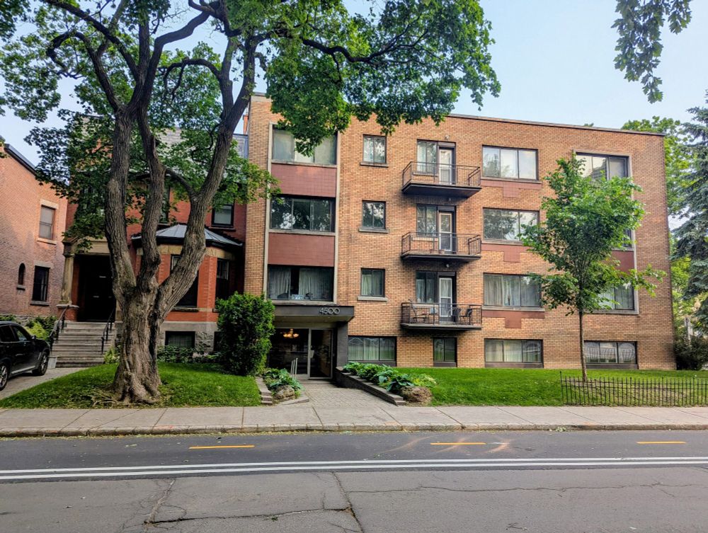 An apartment building attached to a single family home in Montreal.