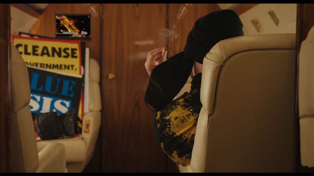 (Eddington spoilers): Shot of a white man smoking on the the Antifa False Flag luxury plane