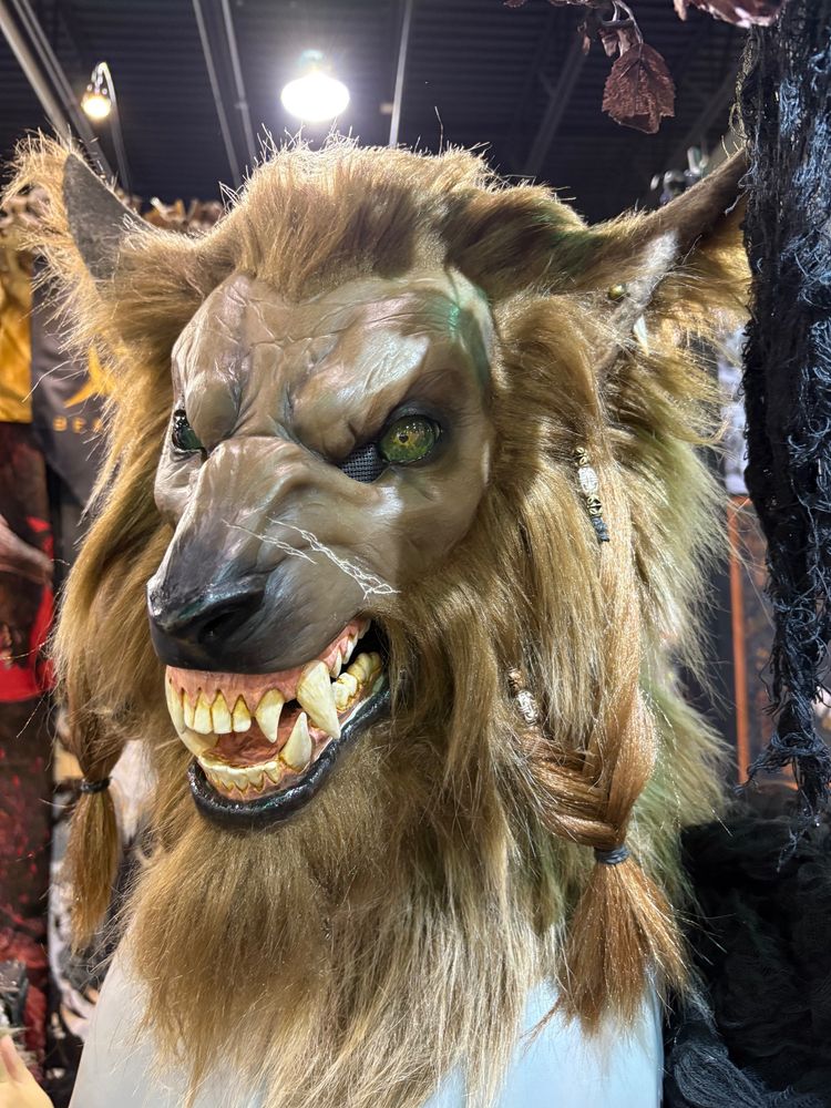 Brown-furred werewolf mask with yellow eyes and intricately braided hair/fur, seen from a slight angle 