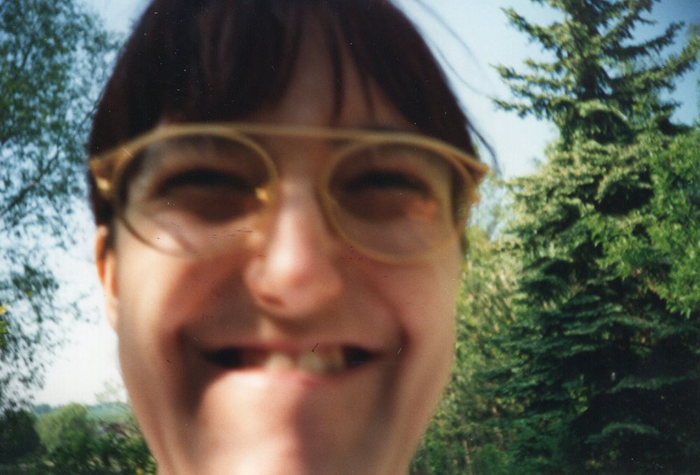 Nahaufnahme einer grinsenden Frau mit Brille