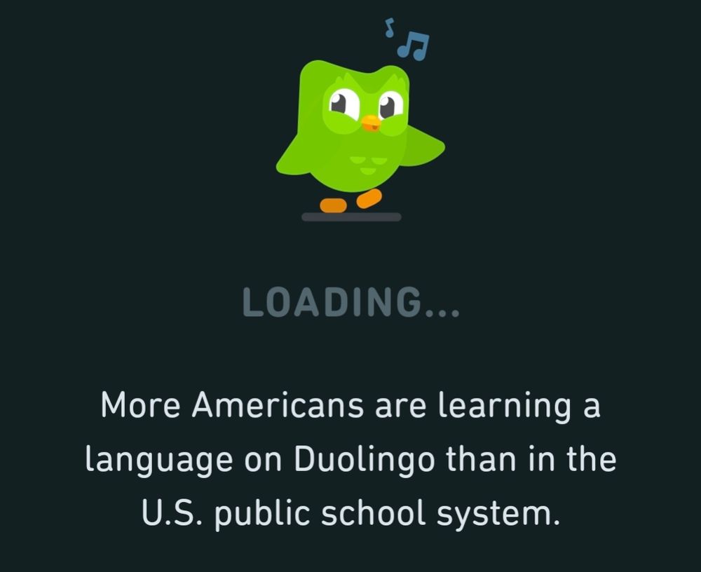 A screenshot of a Duolingo loading screen, that damn owl is whistling above text that says "More Americans are learning a language on Duolingo than in the U.S. public school system."
