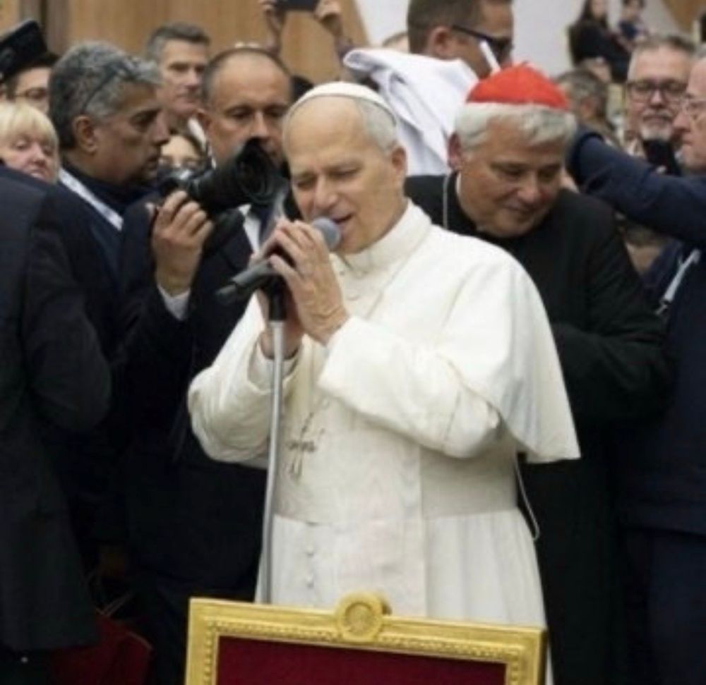 It’s the famous Pope Leo XIV holding a mic with both hands with his eyes closed looking for all the world like he is breaking your heart with a beautiful song 