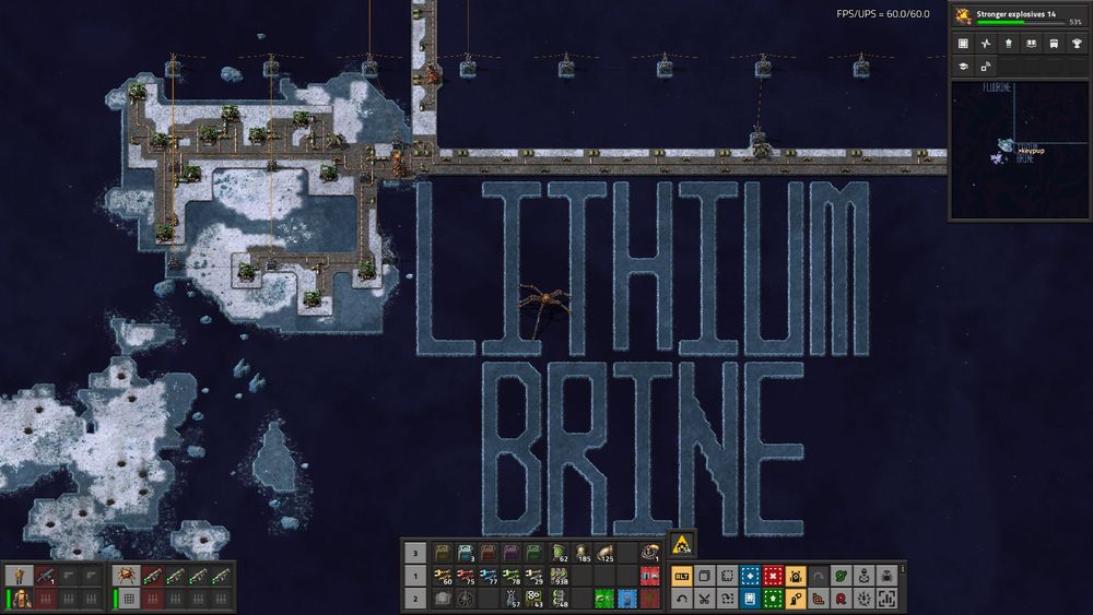 a screenshot of the game Factorio. the words "Lithium Brine" are in large letters made out of ice on a dark blue ocean. there is an island with piping on it running up over the top of the lettering. there is a small spider vehicle inbetween the letters i and T in the lettering in the center of the picture