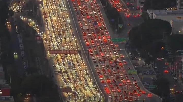 LA Autobahn voll mit Autos deren Scheinwerfer in der Nacht leuchten.