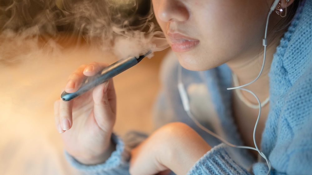 A young person vapes.