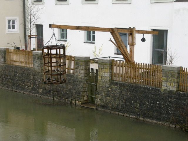 bild einer vorrichtung zum Bäcker schupfen. korb an einem gestell über einem Gewässer zum eintauchen