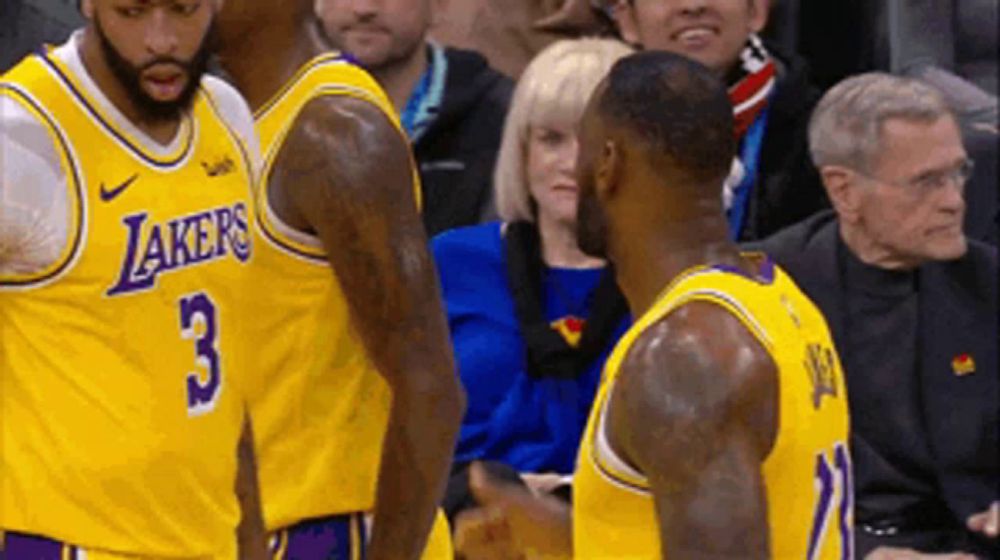 two lakers basketball players are talking to each other during a game