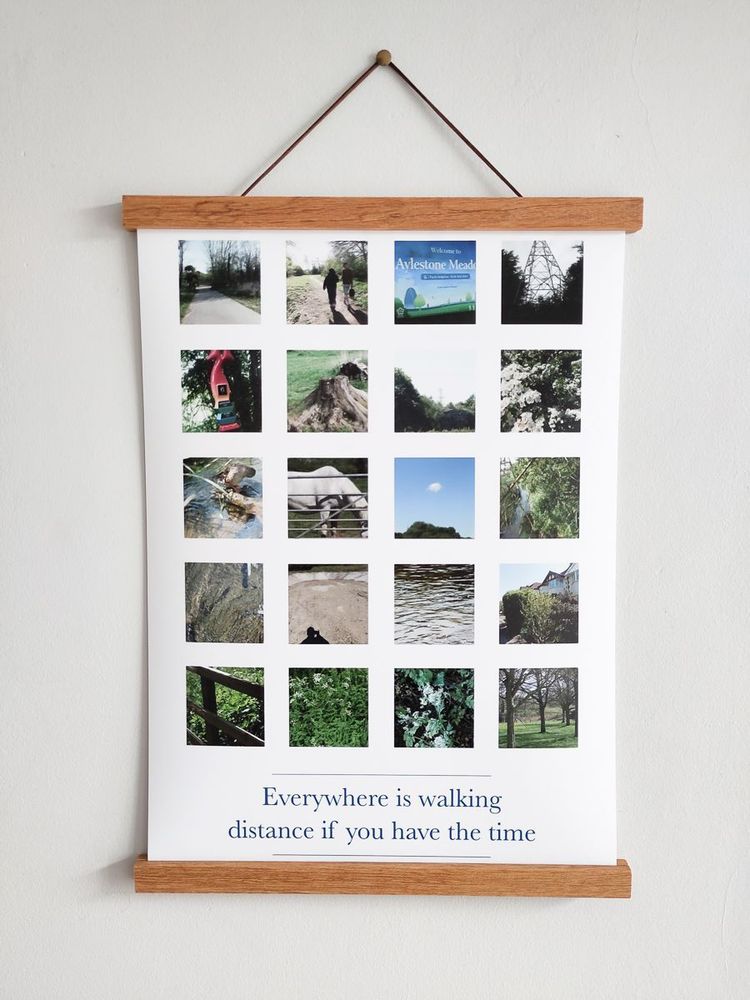 A poster hanging on a wall with a wooden frame at the top and bottom. The poster features a grid of twenty small square photographs showing various outdoor and nature scenes, similar to the first image, with the same quote at the bottom: "Everywhere is walking distance if you have the time." The poster is displayed against a plain light-colored wall.