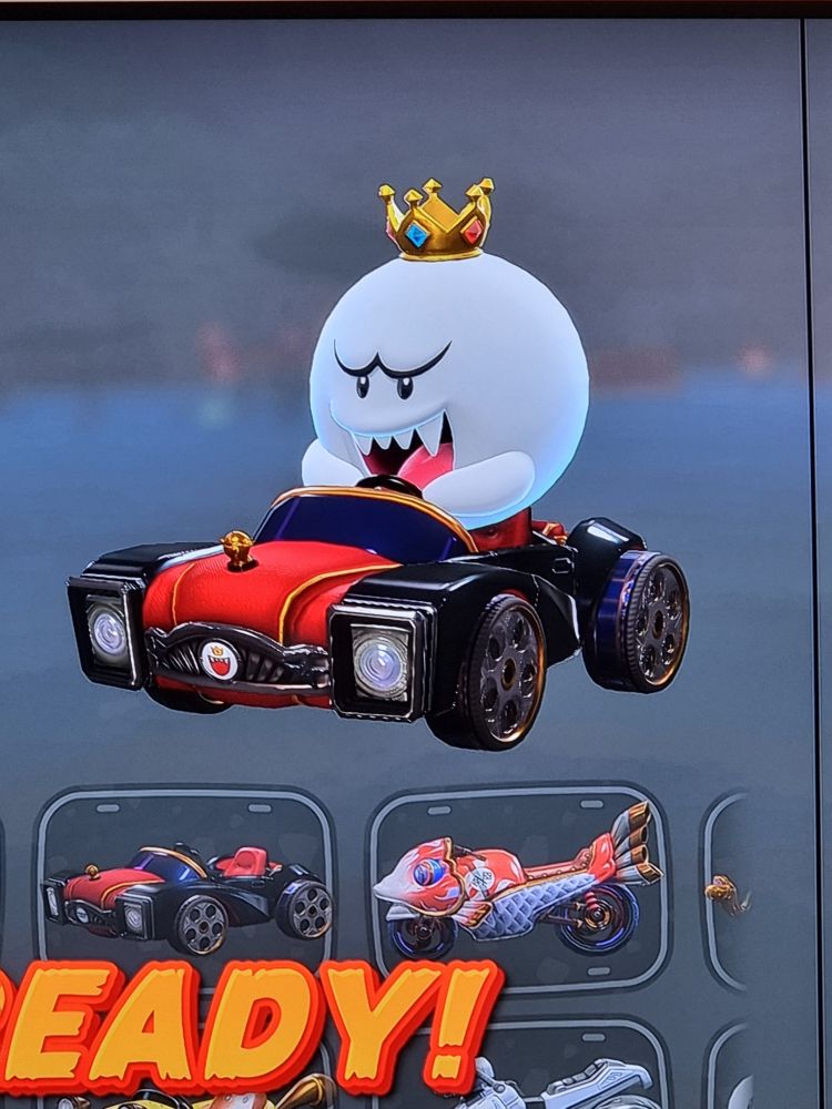 King Boo(a round ghost with a crown) from Mario Kart World, driving a fancy car