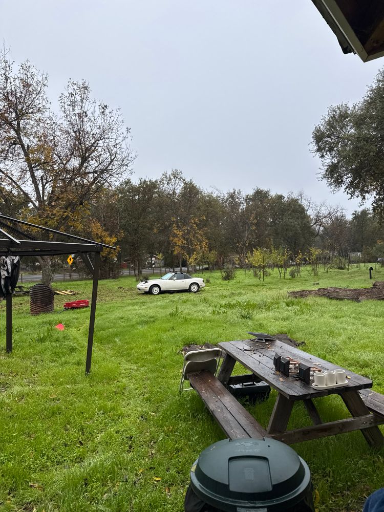 White miata in a lard yard